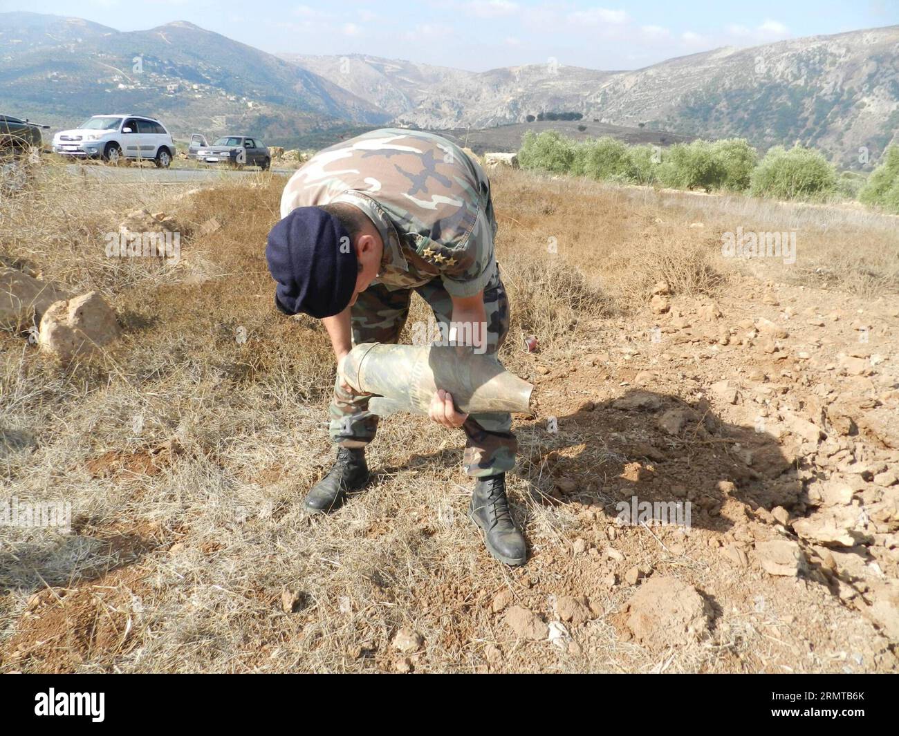(140826) -- BEIRUT, 26 agosto 2014 -- Un soldato libanese controlla un frammento di conchiglie dopo uno sciopero israeliano, nella valle del fiume Litani, a 10 chilometri dai confini con Israele, 26 agosto 2014. Gli assalitori sconosciuti hanno sparato lunedì sera almeno un razzo dal sud del Libano verso i territori occupati nel nord di Israele. Per rappresaglia, l'artiglieria israeliana sparò diversi proiettili sull'area dove i razzi avevano origine. LIBANO-ISRAELE-RAZZO-ATTACK Taher PUBLICATIONxNOTxINxCHN Beirut agosto 26 2014 un soldato libanese dell'esercito controlla un frammento di Shell dopo lo sciopero israeliano alla Litani R. Foto Stock