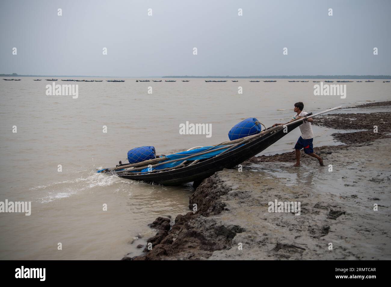 Si vede un pescatore andare a pescare al fiume Shibsha. Non molto tempo fa Kalabogi, un villaggio costiero del Bangladesh, era pieno di terra coltivabile fino a quando l'innalzamento del livello del mare non cominciò a ingoiare l'area fino alla baia del Bengala. Frequenti cicloni e inondazioni hanno colpito il villaggio dalla fine degli anni '1990 Nel 2009, un grande ciclone chiamato Aila distrusse i 1.400 chilometri di argini, 8.800 chilometri di strade e circa 50.000 ettari di terreno agricolo. Diverse centinaia di persone sono state uccise nel disastro. I contadini di Kalabogi sono stati i più colpiti. Come la maggior parte della terra del villaggio Foto Stock