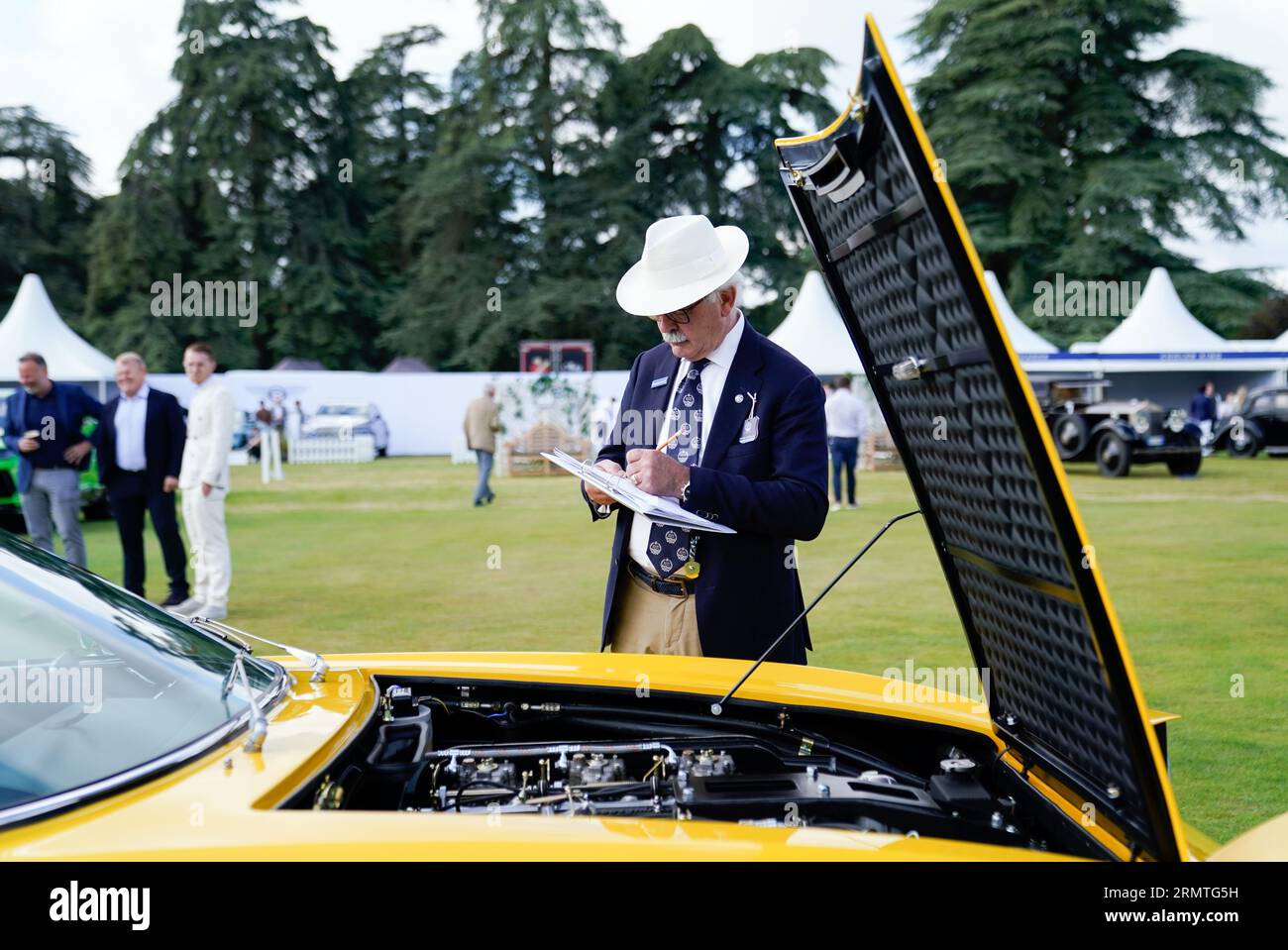 Un giudice prende appunti mentre guarda il motore di una Lamborghini Islero del 1969 durante il giorno di apertura del Salon prive Concours d'Elegance al Blenheim Palace nell'Oxfordshire. L'evento vedrà una serie di case automobilistiche di lusso presentare in anteprima i loro nuovi modelli. Data foto: Mercoledì 30 agosto 2023. Foto Stock