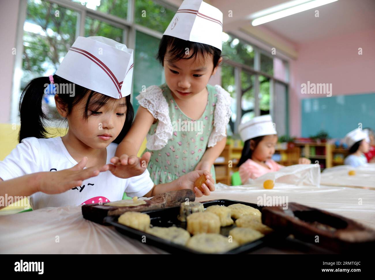 I bambini usano gli stampi per preparare le torte lunari a Hefei, capitale della provincia di Anhui della Cina orientale, 4 settembre 2014. Il Mid-Autumn Festival, che cade l'8 settembre di quest'anno, è un tradizionale festival cinese per riunioni di famiglia, durante il quale la gente potrà godersi la luna piena insieme e mangiare torte lunari - piccole torte rotonde con una varietà di ripieni. )(wjq) CHINA-ANHUI-HEFEI-MOONCAKE (CN) LiuxJunxi PUBLICATIONxNOTxINxCHN i bambini usano le muffe per preparare le torte lunari nella provincia di Anhui, capitale della Cina orientale, 4 settembre 2014 il Mid Autumn Festival che cade L'8 settembre di quest'anno È un tradizionale festival cinese per Foto Stock