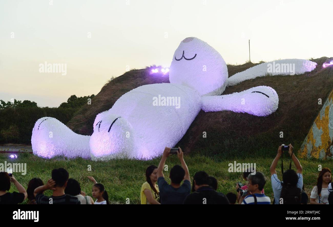 (140906) -- TAIPEI, 6 settembre 2014 -- la gente guarda un Moon Rabbit alto 25 metri, creato dall'artista olandese Florentijn Hoffman nella contea di Taoyuan, a Taiwan, 6 settembre 2014. Hoffman, che ha anche creato l'anatra Ruber, è stato ispirato dal tradizionale mito cinese sul coniglio che vive sulla luna. (mp) CHINA-TAOYUAN COUNTY-MOON RABBIT (CN) WangxQingqin PUBLICATIONxNOTxINxCHN Taipei 6 settembre 2014 Celebrities Watch a Tall Moon Rabbit di 25 metri creato dall'artista olandese Hoffman nella contea di TAIWAN della Cina sudorientale 6 settembre 2014 Hoffman che ha così creato Ruber Duck What Inspired by Th Foto Stock