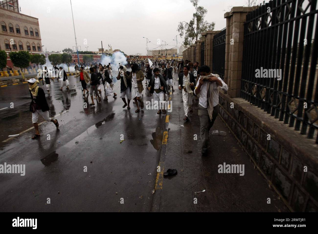 (140907) -- SANAA, 7 settembre 2014 -- i manifestanti fuggono dal gas lacrimogeno durante gli scontri con la polizia antisommossa a Sanaa, Yemen, il 7 settembre 2014. La polizia antisommossa yemenita domenica sera ha sparato gas lacrimogeni per disperdere i ribelli Shiite Houth che hanno bloccato una strada principale per l'aeroporto internazionale di Sanaa in un'escalation della loro situazione di stallo con il governo, i testimoni hanno detto a Xinhua. Circa 10 manifestanti sciiti sono rimasti feriti negli scontri. YEMEN-SANAA-CLASH MohammedxMohammed PUBLICATIONxNOTxINxCHN Sanaa 7 settembre 2014 i manifestanti fuggono dal gas lacrimogeno durante gli scontri con la polizia antisommossa a Sanaa Yemen IL 7 settembre 201 Foto Stock