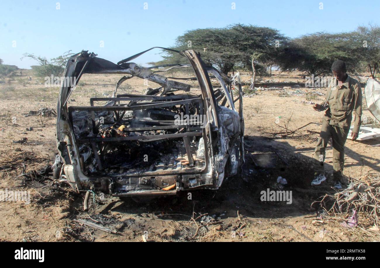 (140908) -- MOGADISCIO, 8 settembre 2014 -- Un personale militare controlla il sito di una bomba suicida colpita da un convoglio della missione dell'Unione africana in Somalia (AMISOM) su una strada che collega Mogadiscio e Afgooye, una piccola città 20 km a ovest della capitale, 8 settembre 2014. Il gruppo islamista al-Shabaab lunedì ha rivendicato la responsabilità di due attacchi suicidi di autobomba che hanno ucciso almeno 12 persone in Somalia, hanno detto fonti della polizia. L'altra bomba suicida ha colpito un posto di blocco militare alla periferia di Mogadiscio lunedì, ferendo due persone, tra cui un funzionario del governo locale. ) SOMALIA-MOGADISCIO-SUI Foto Stock
