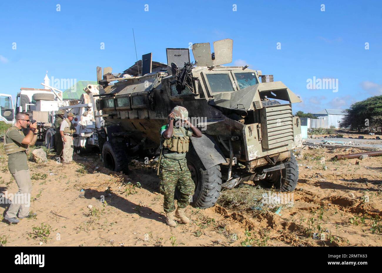 (140908) -- MOGADISCIO, 8 settembre 2014 -- gli investigatori controllano il sito di una bomba suicida che colpisce un convoglio della missione dell'Unione africana in Somalia (AMISOM) su una strada che collega Mogadiscio e Afgooye, una piccola città 20 km a ovest della capitale, 8 settembre 2014. Il gruppo islamista al-Shabaab lunedì ha rivendicato la responsabilità di due attacchi suicidi di autobomba che hanno ucciso almeno 12 persone in Somalia, hanno detto fonti della polizia. L'altra bomba suicida ha colpito un posto di blocco militare alla periferia di Mogadiscio lunedì, ferendo due persone, tra cui un funzionario del governo locale. ) SOMALIA-MOGADISCIO-SUICIDIO BOM Foto Stock