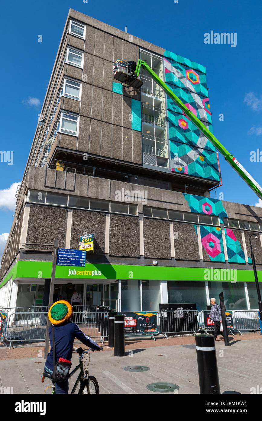 High Street, Southend on Sea, Essex, Regno Unito. 30 agosto 2023. Annunciato come il più grande festival di Street art d'Europa, Southend continua a celebrare il suo nuovo status di città con l'evento City Jam. Oltre 200 artisti di strada locali, nazionali e internazionali stanno mettendo in mostra le loro abilità in 100 sedi in tutto il centro della città. Sono state allestite alcune pareti temporanee, ma gli artisti stanno anche decorando i lati degli edifici e altre strutture permanenti. A partire dal primo al terzo settembre, gli artisti hanno iniziato a lavorare sui murales più grandi in modo da essere pronti per l'evento. Lavoro ad altezza superiore a St. Alta Foto Stock