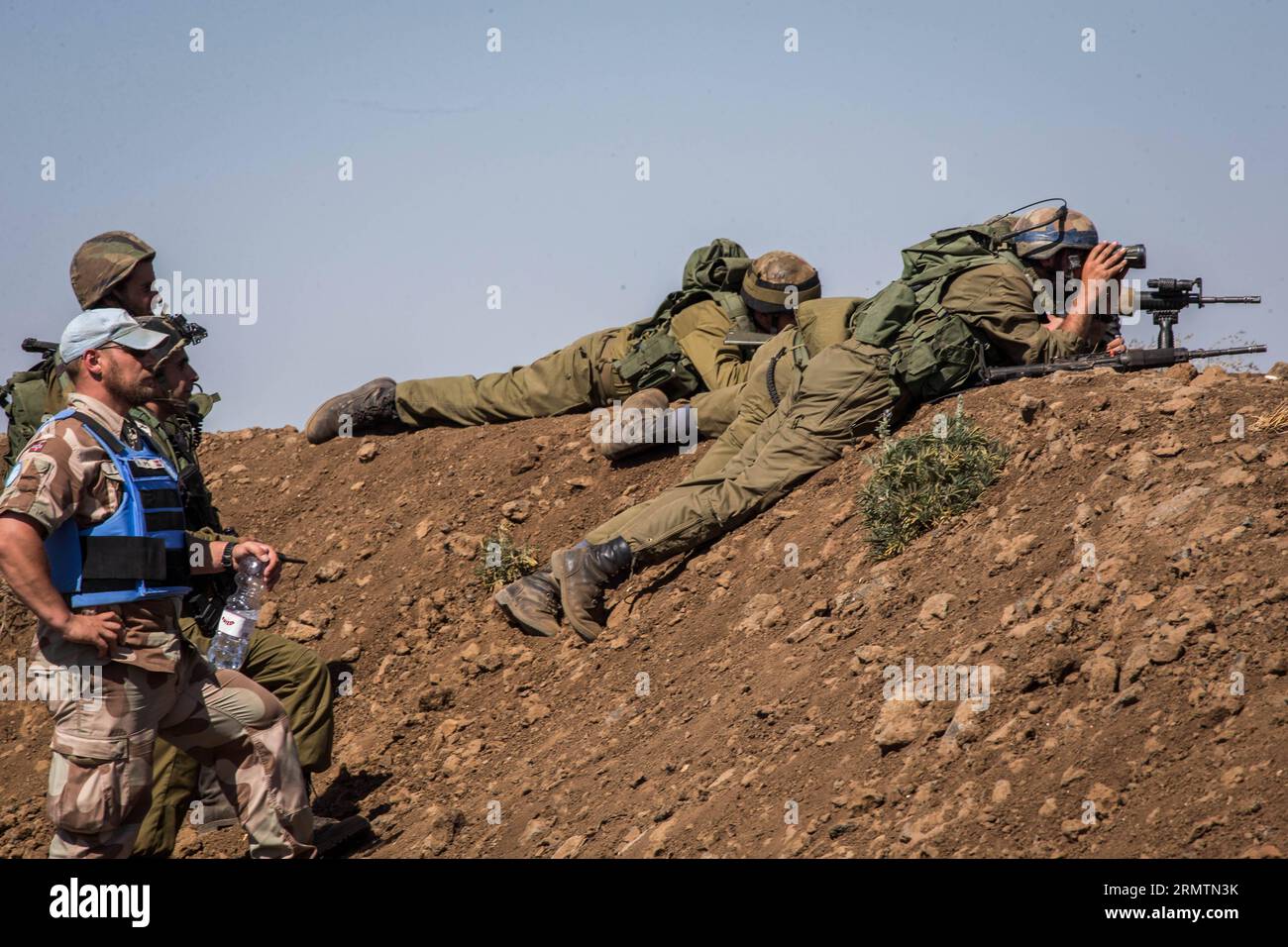 (140912) -- GOLAN HEIGHTS, 11 settembre 2014 -- i soldati israeliani e i membri dei pacificatori delle Nazioni Unite si affacciano sul confine delle alture del Golan durante il rilascio delle forze di pace delle Nazioni Unite dalle Figi, l'11 settembre 2014. Il Segretario generale delle Nazioni Unite Ban Ki-Moon giovedì ha accolto con favore il rilascio di 45 forze di pace delle Figi che erano state detenute nelle alture del Golan per due settimane. Giovedì scorso le Nazioni Unite hanno dichiarato che le Fijiane sono state consegnate alle forze di osservazione per il disimpegno delle Nazioni Unite (UNDOF) alle 14:30 ora locale. Tutti i 45 peacekeeper sono in buone condizioni e saranno sottoposti a valutazione medica. ) MIDEAST-GOLAN HEIGHTS-DETA Foto Stock