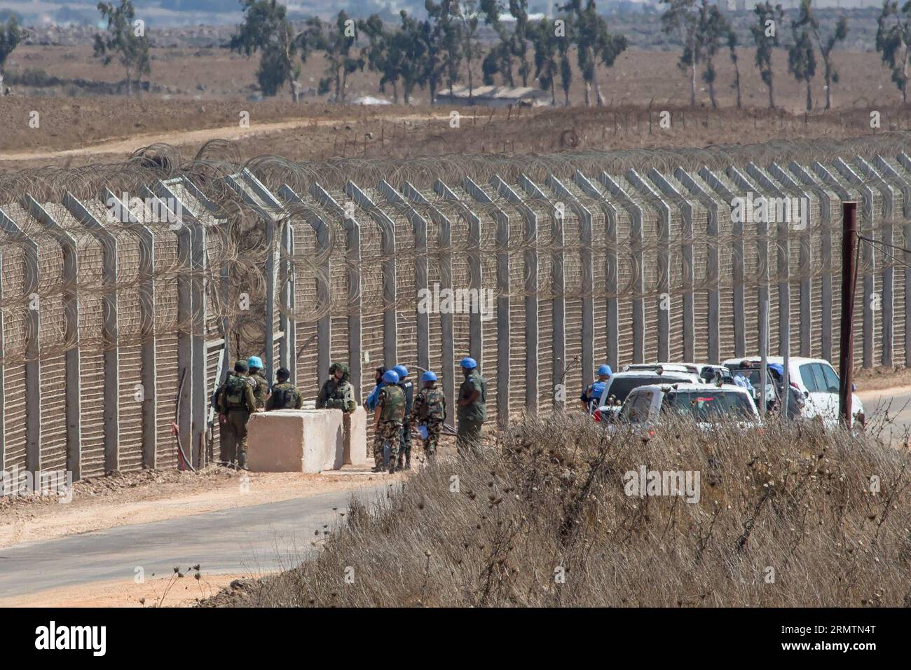 (140912) -- GOLAN HEIGHTS, 11 settembre 2014 -- soldati israeliani e membri dei pacificatori delle Nazioni Unite attendono al confine per il rilascio delle forze di pace delle Nazioni Unite dalle Figi, vicino al villaggio siriano di al Rafeed, l'11 settembre 2014. Il Segretario generale delle Nazioni Unite Ban Ki-Moon giovedì ha accolto con favore il rilascio di 45 forze di pace delle Figi che erano state detenute nelle alture del Golan per due settimane. Giovedì scorso le Nazioni Unite hanno dichiarato che le Fijiane sono state consegnate alle forze di osservazione per il disimpegno delle Nazioni Unite (UNDOF) alle 14:30 ora locale. Tutti i 45 peacekeeper sono in buone condizioni e saranno sottoposti a valutazione medica. ) MIDEAST-GOLA Foto Stock