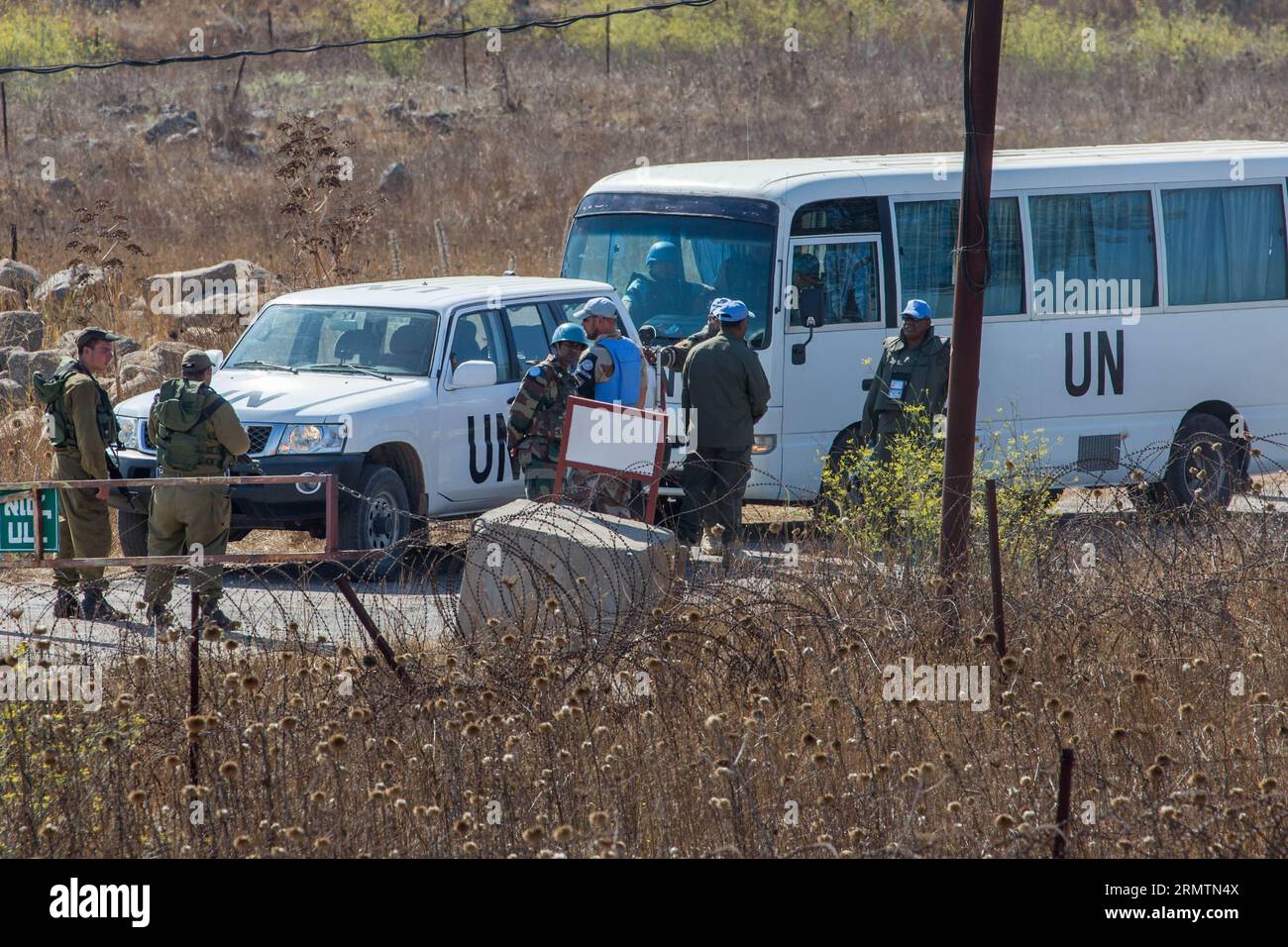 (140912) -- GOLAN HEIGHTS, 11 settembre 2014 -- soldati israeliani e membri dei pacificatori delle Nazioni Unite attendono al confine per il rilascio delle forze di pace delle Nazioni Unite dalle Figi, vicino al villaggio siriano di al Rafeed, l'11 settembre 2014. Il Segretario generale delle Nazioni Unite Ban Ki-Moon giovedì ha accolto con favore il rilascio di 45 forze di pace delle Figi che erano state detenute nelle alture del Golan per due settimane. Giovedì scorso le Nazioni Unite hanno dichiarato che le Fijiane sono state consegnate alle forze di osservazione per il disimpegno delle Nazioni Unite (UNDOF) alle 14:30 ora locale. Tutti i 45 peacekeeper sono in buone condizioni e saranno sottoposti a valutazione medica. ) MIDEAST-GOLA Foto Stock