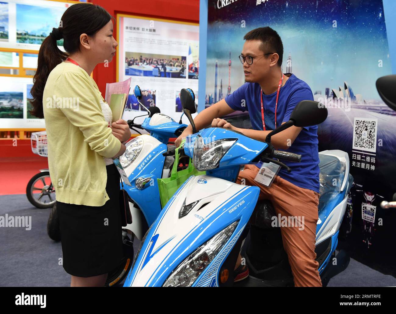 (140917) -- NANNING, 17 settembre 2014 -- Un uomo (R) apprende di uno scooter alimentato a batteria durante l'undicesima Expo Cina-ASEAN a Nanning, capitale della regione autonoma del Guangxi Zhuang della Cina meridionale, 17 settembre 2014. Le nuove energie e le attrezzature high tech hanno attirato sia espositori che visitatori dal paese e dall'estero durante l'11° CAEXPO tenutosi a Nanning dal 16 al 19 settembre. CAEXPO si svolge annualmente a Nanning e dovrebbe promuovere il libero scambio tra la Cina e i paesi dell'ASEAN. (lmm) CHINA-NANNING-CAEXPO-NEW ENERGY-HIGH TECH (CN) ZhouxHua PUBLICATIONxNOTxINxCHN Nanning 17 settembre 2014 a Man r le Foto Stock