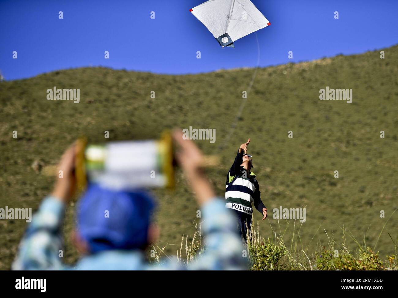 (140922) -- LHASA, -- due bambini volano aquiloni a Lhasa, capitale della regione autonoma del Tibet nel sud-ovest della Cina, 19 settembre 2014. Gli amanti degli aquiloni a Lhasa hanno la tradizione di combattere gli aquiloni sulle rive del fiume Lhasa da agosto a ottobre ogni anno. Cercando di pilotare aquiloni in combattimento aereo, i partecipanti devono fare uno sforzo per superare o disabilitare in qualche modo l'aquilone di un avversario. Il combattimento degli aquiloni a Lhasa è stato elencato come patrimonio culturale immateriale nazionale della Cina nel 2006. ) (lfj) CHINA-LHASA-KITE FIGHTING (CN) PurbuxZhaxi PUBLICATIONxNOTxINxCHN Lhasa due bambini volano aquiloni a Lhasa capitale di S Foto Stock