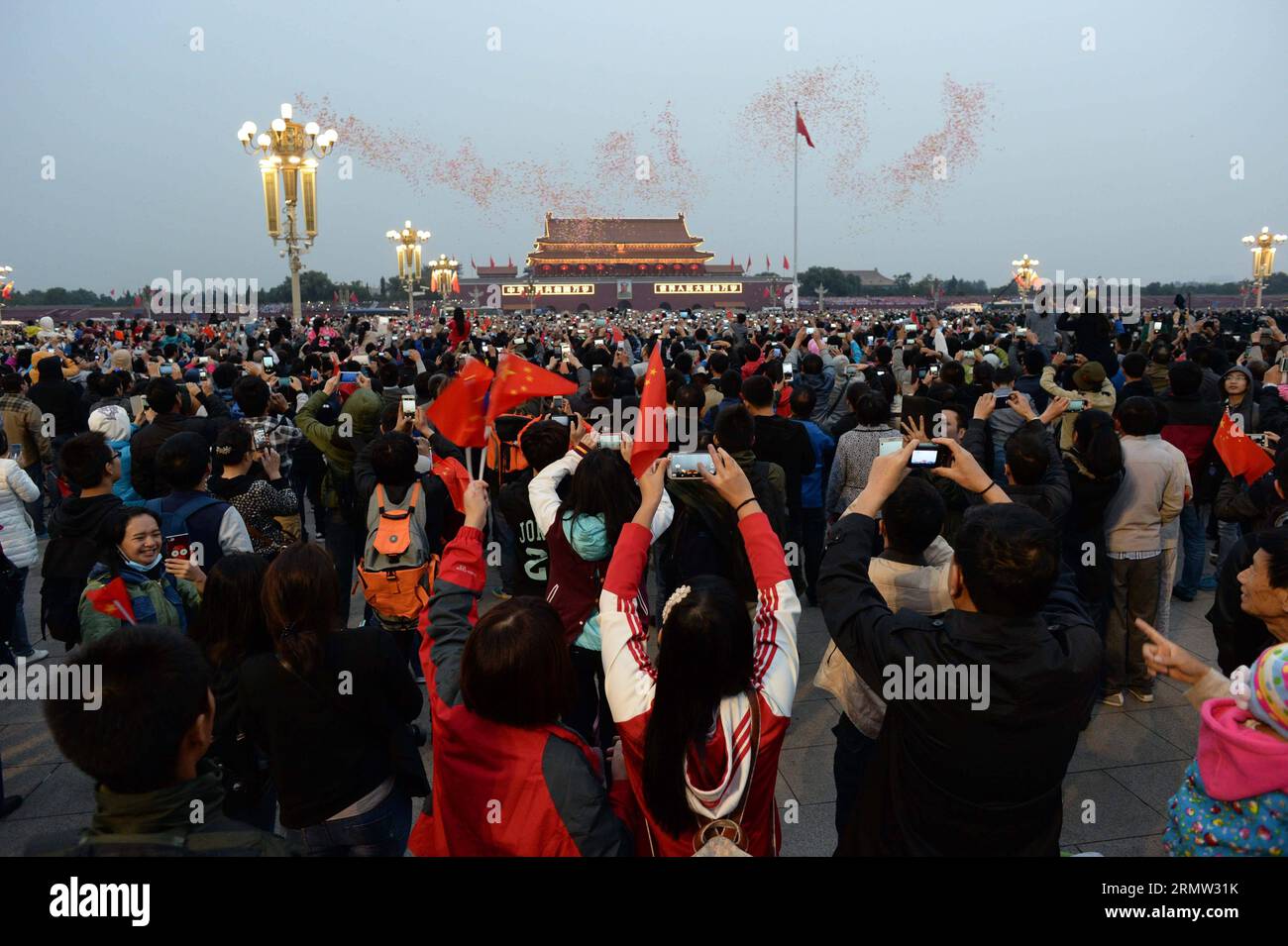 (141001) -- PECHINO, 1 ottobre 2014 -- le persone scattano foto di palloncini che volano nel cielo dopo la cerimonia di innalzamento della bandiera che segna il 65° anniversario della fondazione della Repubblica Popolare Cinese nella Piazza Tian anmen a Pechino, capitale della Cina, 1° ottobre 2014, anche la giornata Nazionale Cinese. ) (lfj) CERIMONIA DI INNALZAMENTO DELLA BANDIERA IN CINA (CN) ChenxYehua PUBLICATIONxNOTxINxCHN Pechino OCT 1 2014 celebrità scattano foto di palloni che volano nel cielo dopo la cerimonia di innalzamento della bandiera che segna il 65° anniversario della fondazione della Repubblica di Cina delle celebrità IN Piazza Tian anmen Foto Stock