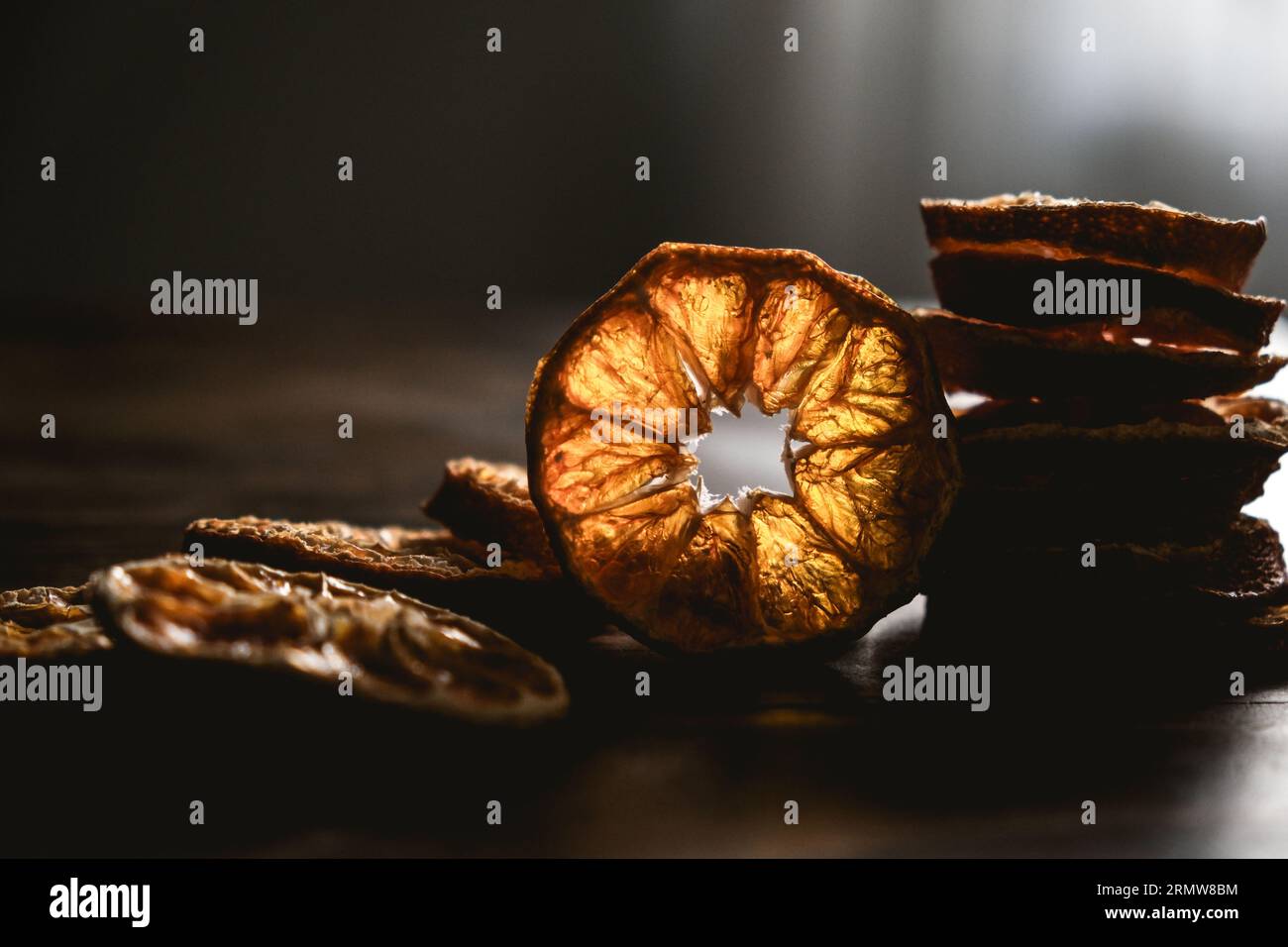 Fette di arancia secche sul tavolo di legno. Agrumi secchi. Agrumi secchi sul tavolo. Vista superiore delle sezioni arancioni. Mandarino o mandarino Foto Stock
