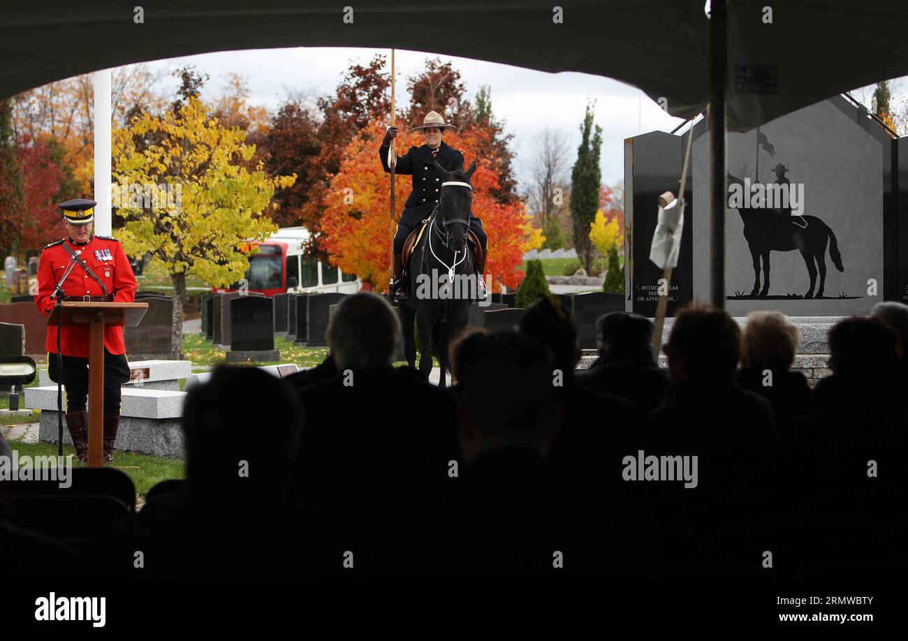 Un ufficiale della Royal Canadian Mounted Police siede sul suo cavallo, mentre l'assistente commissario della RCMP Joe Oliver parla al memoriale nel National Memorial Cemetery della RCMP a Ottawa, Canada, il 19 ottobre 2014. Il cimitero, aperto ai membri in pensione e in carica del RCMP, ai membri civili, ai conservieri speciali e ai membri delle loro famiglie, è stato celebrato domenica per il decimo anniversario del cimitero. Cole Burston)(lxl) CANADA-OTTAWA-RCMP-MEMORIAL CEMETERY-ANNIVERSARY libaodong PUBLICATIONxNOTxINxCHN un ufficiale della Royal Canadian Mounted Police siede SUL suo cavallo come vice Commissario della RCMP Joe Olive Foto Stock