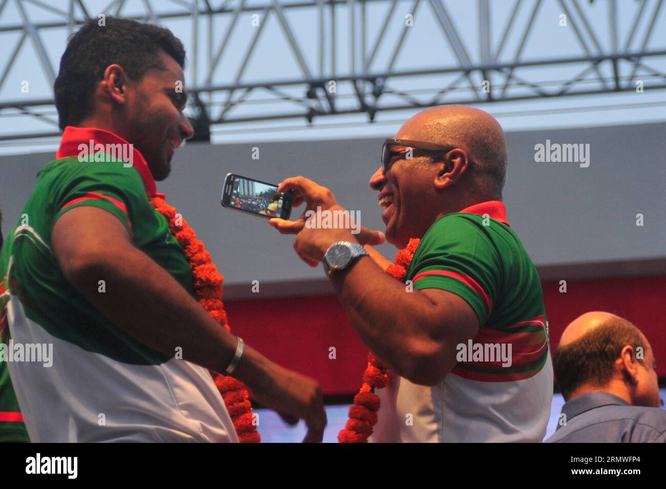 Il capitano Mashrafe Bin Mortaza e il capo allenatore Chandika Hathrusingha scattano dei selfie durante i giocatori di cricket nazionali del Bangladesh che ricevono un caloroso benvenuto da parte del Foto Stock