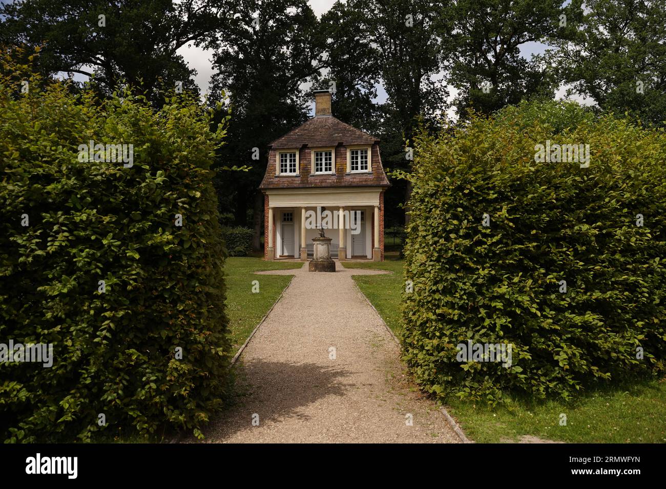 Un affascinante cottage per i giochi si trova ai margini di un giardino perenne ombreggiato Foto Stock