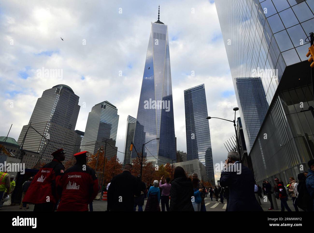 (141112) -- NEW YORK, 12 novembre 2014 -- le persone scattano foto di un ponteggio che trasporta lavavetri pende in alto dalla superficie del One World Trade Center di New York, Stati Uniti, 12 novembre 2014. Due lavavetri sono rimasti intrappolati per un'ora mercoledì su un ponteggio sospeso in alto sulla faccia del One World Trade Center, l'edificio più alto dell'emisfero occidentale. I vigili del fuoco hanno attraversato una finestra del 69° piano verso l'alto e li hanno tirati delicatamente all'interno per sicurezza. ) US-NEW YORK-ONE WORLD TRADE CENTER-ACCIDENT-WINDOW-WASHER WangxLei PUBLICATIONxNOTxINxCHN New York 12 novembre 2014 celebrità prendono Foto Stock