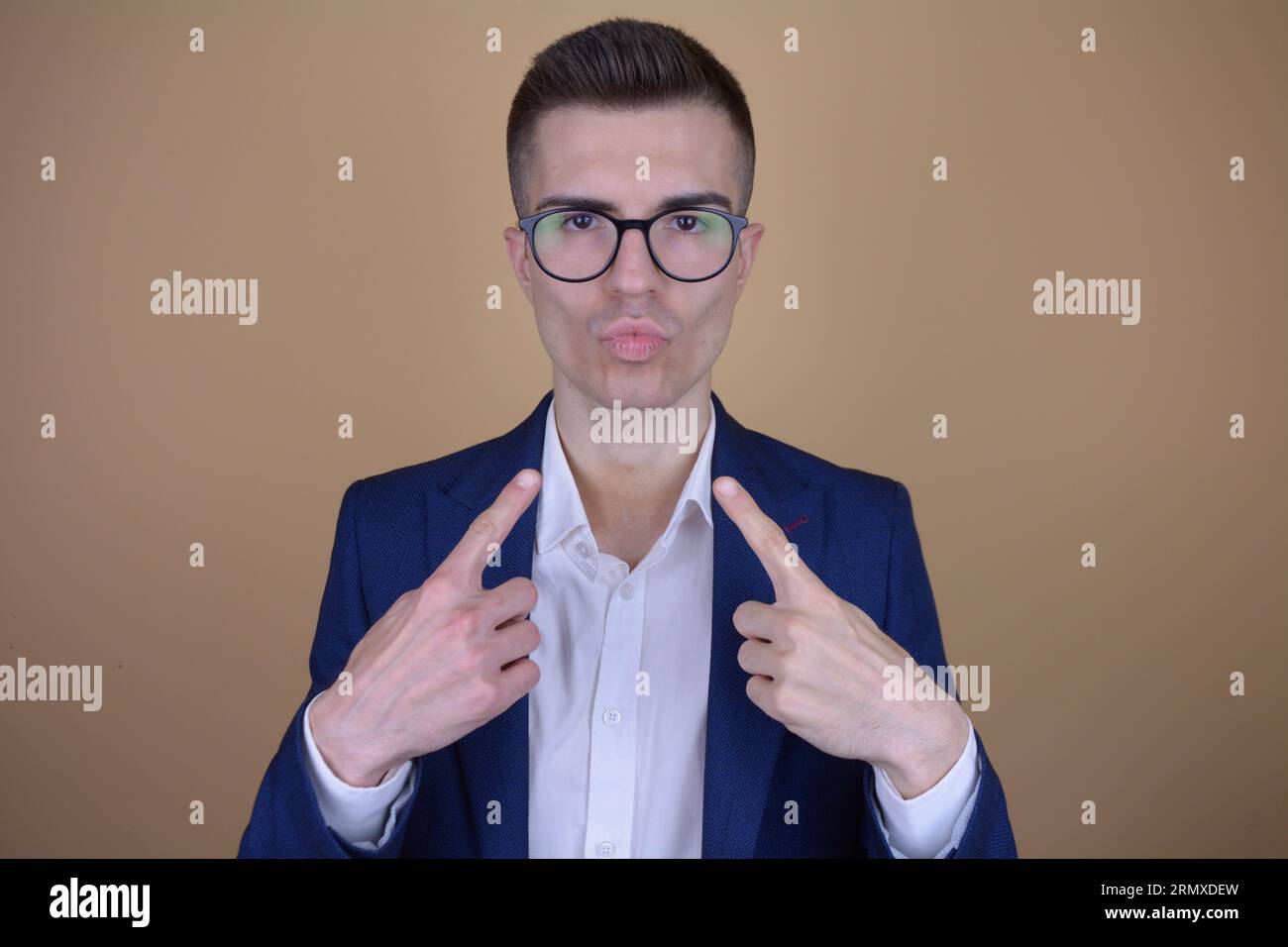 Troppo sicuro Young bell'uomo elegante che punta su se stesso su uno sfondo isolato Foto Stock