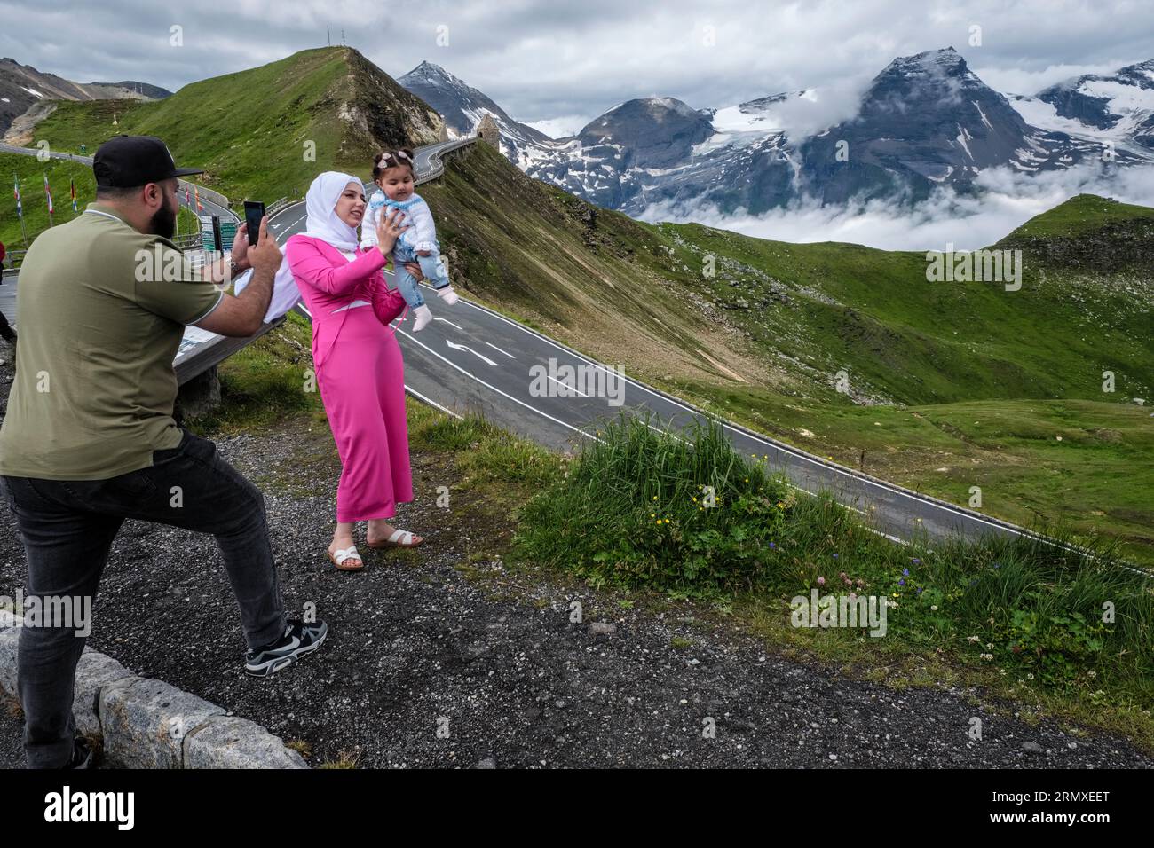 Un turista del Medio Oriente che fotografa la moglie e la figlia alla Grossglockner High Alpine Road, Parco Nazionale alti Tauri, Austria Foto Stock