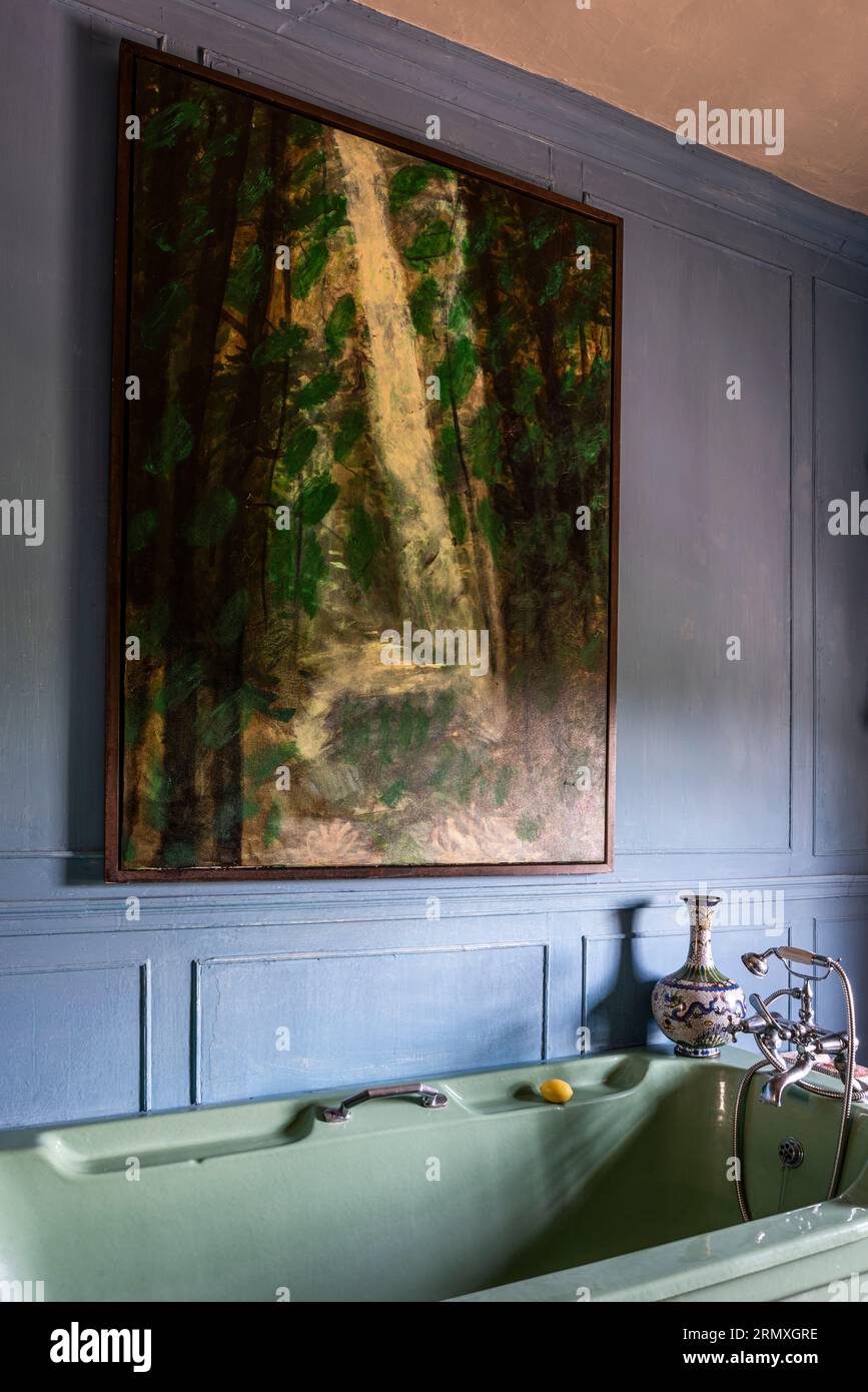 Artowrk incorniciato sopra il bagno su pareti rivestite in pannelli nel XVIII secolo di conversione di loft fioriti vicino a Penzance in Cornovaglia, Regno Unito Foto Stock
