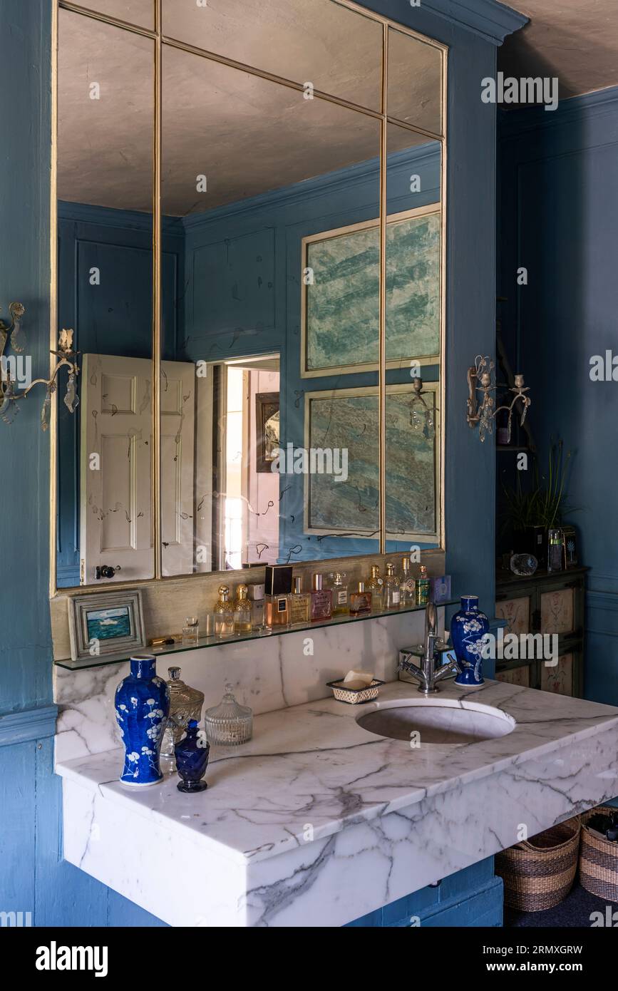 Grande specchio sopra il lavandino in marmo in bagno di conversione floreale del XVIII secolo vicino a Penzance in Cornovaglia, Regno Unito Foto Stock
