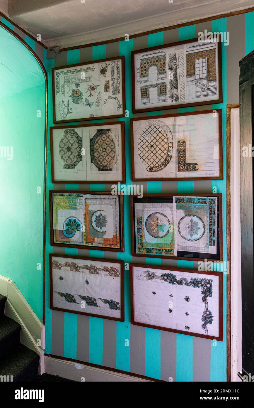 Disegni incorniciati su parete a strisce in un loft fiorito del XVIII secolo vicino a Penzance in Cornovaglia, Regno Unito Foto Stock
