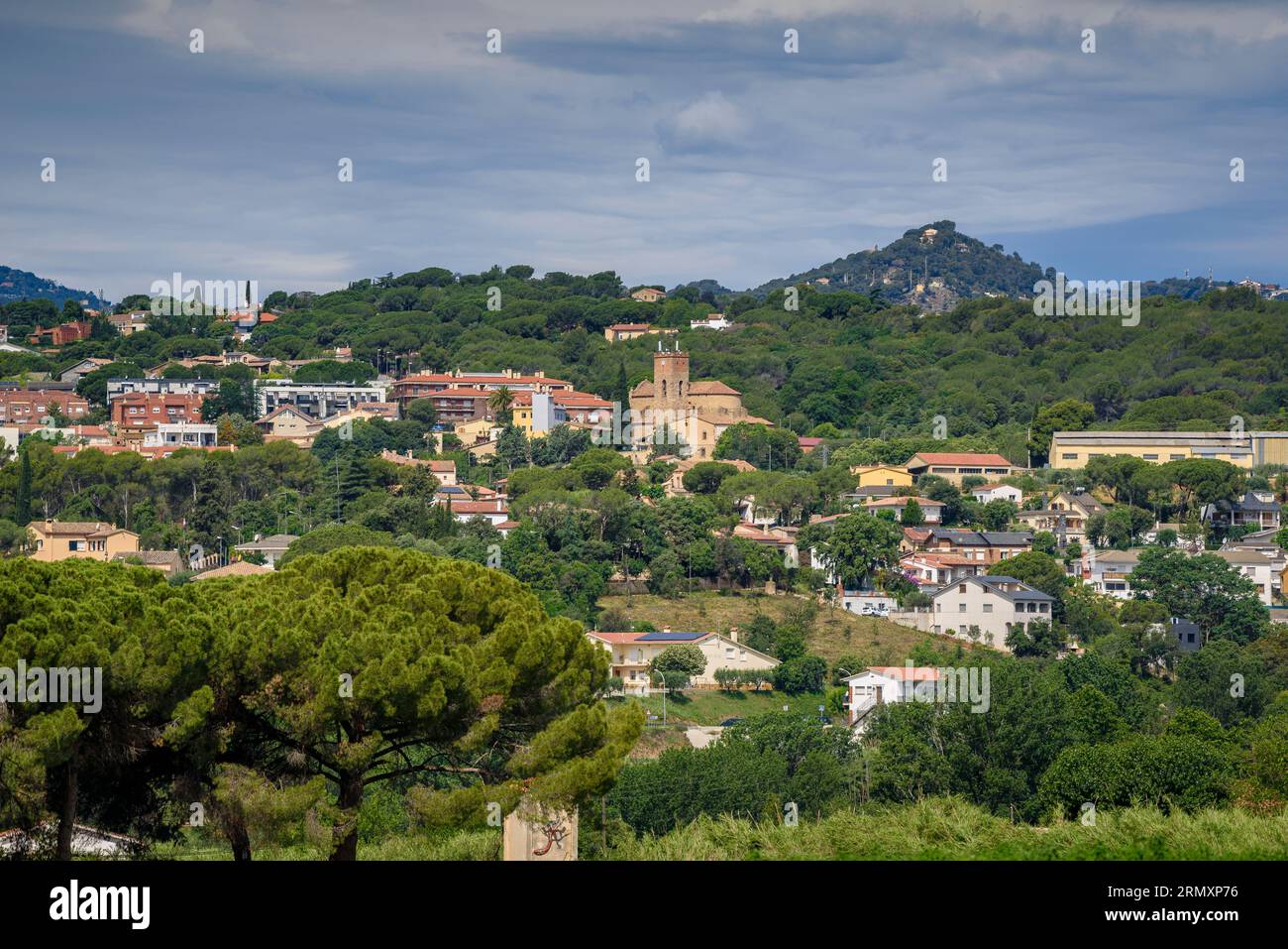 Villaggio di Santa Eulàlia de Roncaana, circondato da campi verdi e nuvole in primavera (Vallès Oriental, Barcellona, Catalogna, Spagna) Foto Stock