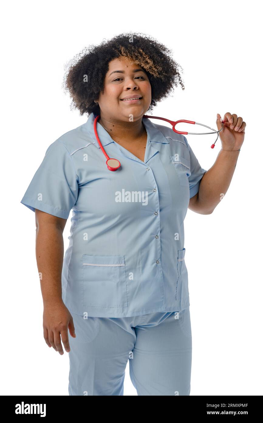 ritratto verticale di donna medica afro latina venezuelana, con uniforme blu, sorridente in piedi e guardando la fotocamera su sfondo bianco Foto Stock