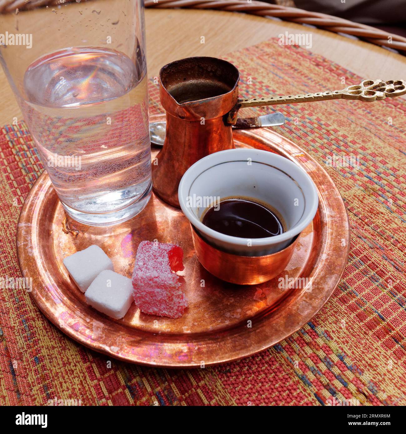 Caffè bosniaco con cubetti di zucchero, Turkish Delight , servito su un vassoio di rame e utensili e un bicchiere d'acqua nella città di Sarajevo, 30 agosto 2023 Foto Stock