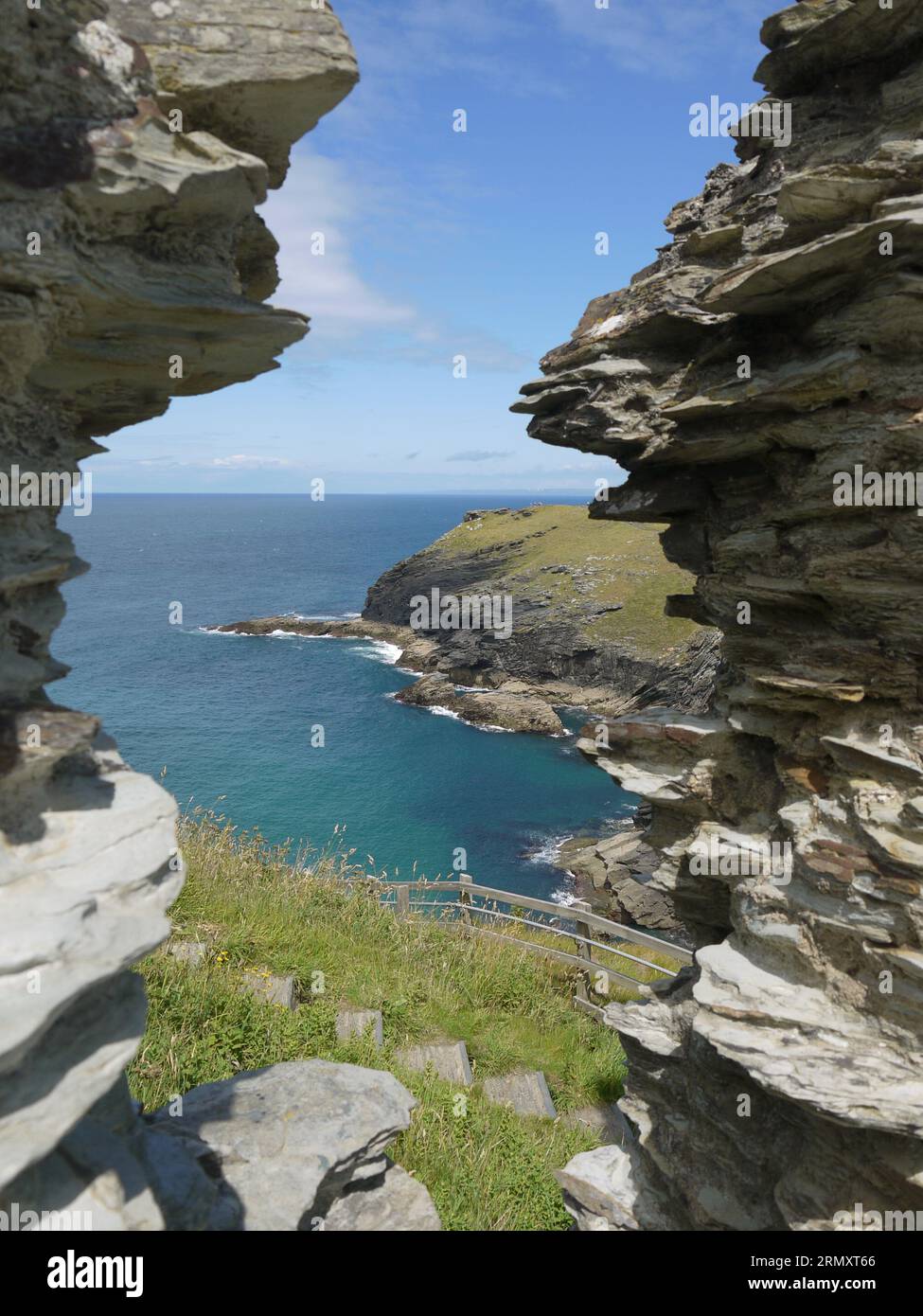 Tintagel, Cornovaglia, Regno Unito - 1° luglio 2022: Vista della baia di Tintagel incorniciata dalle mura del castello di Tintagel Foto Stock