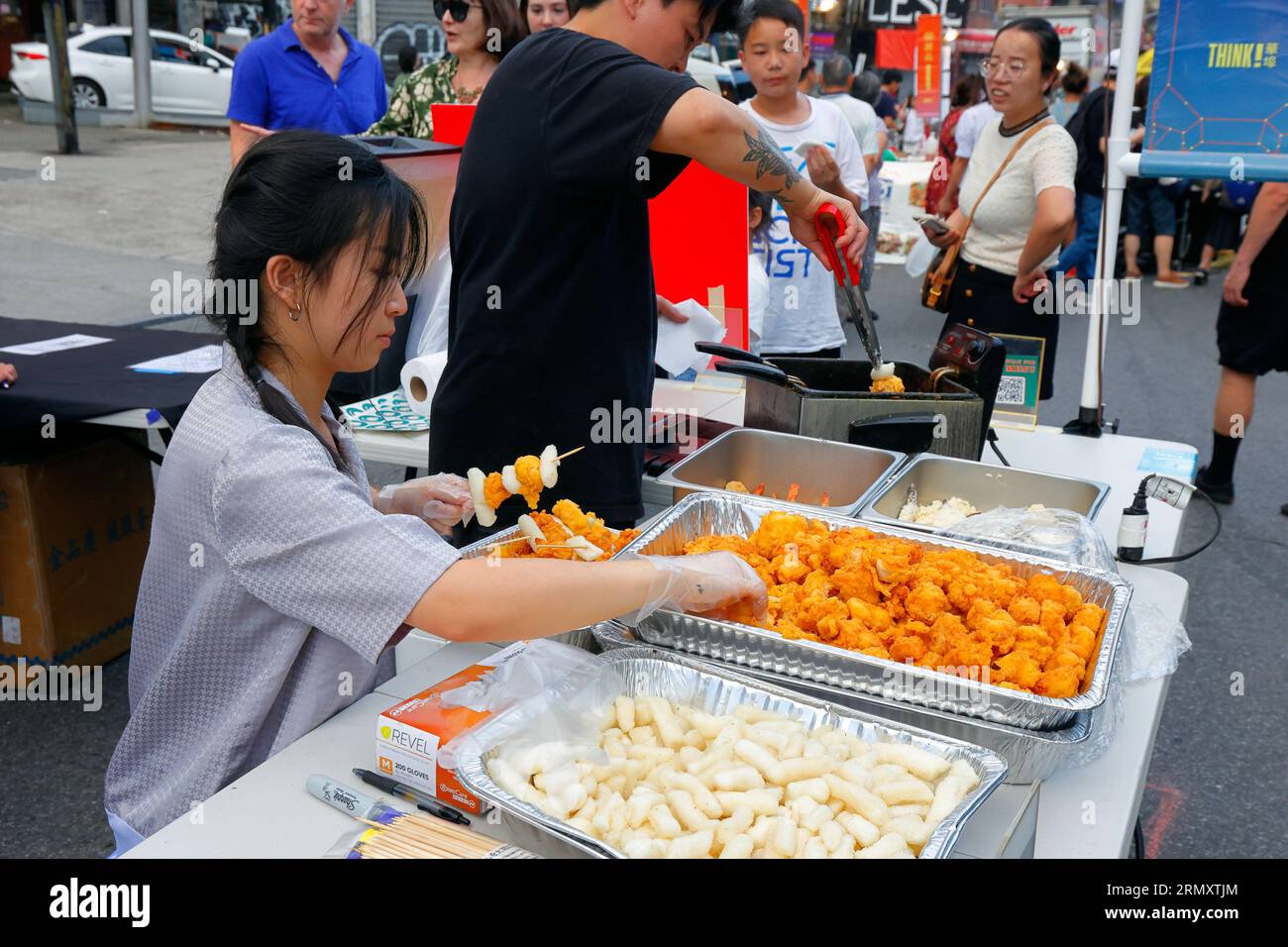 Un lavoratore Round K di Sol prepara spiedini di torta di pollo e riso a un pensiero! Evento del mercato notturno di Chinatown a Chinatown, New York, 23 luglio 2023. Foto Stock