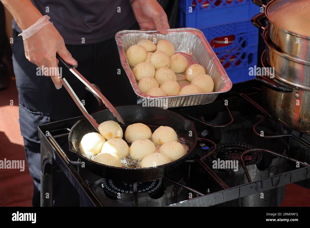 Il personale del Nan Xiang Express prepara panini di maiale fritti in padella alla fiera di strada del Dragon Fes food Festival a New York, il 27 agosto 2023. Foto Stock