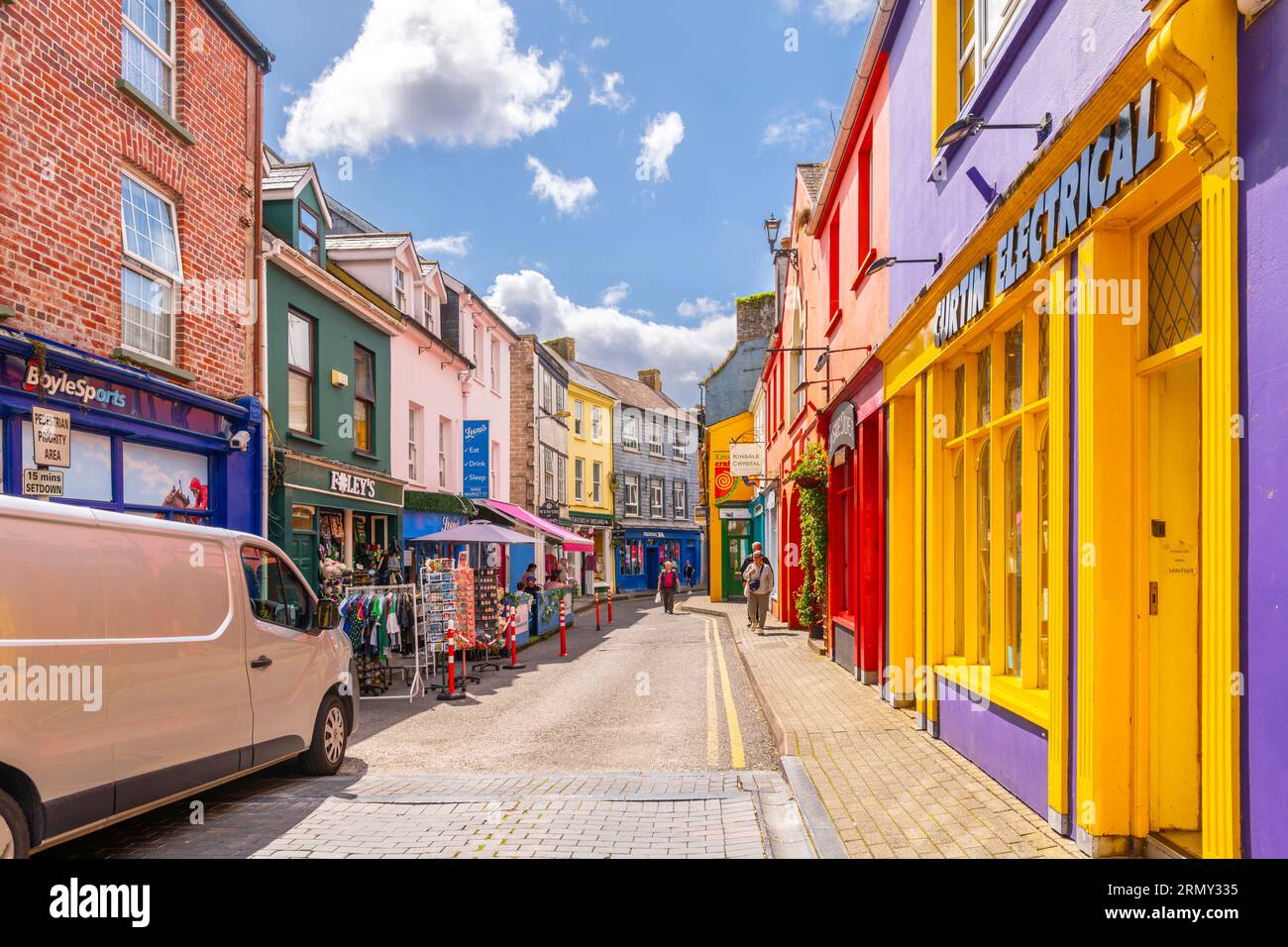 Stradine strette di negozi dai colori vivaci e caffetterie nel centro storico della piccola cittadina portuale di pescatori di Kinsale, nella contea di Cork, in Irlanda. Foto Stock