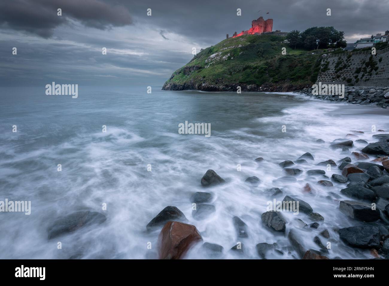 Criccieth Castle illuminato di sera, Gwynedd, Galles Foto Stock