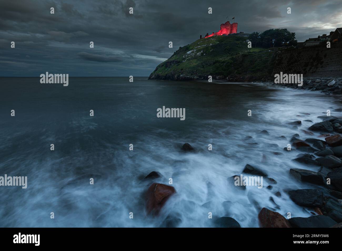 Criccieth Castle illuminato di sera, Gwynedd, Galles Foto Stock