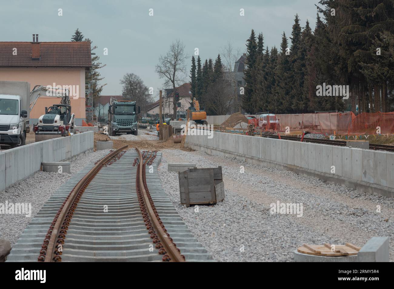 Modernizzazione della vecchia stazione ferroviaria di Domzale, città periferica di lubiana. Lavoratori che posano nuovi cingoli con ghiaia e nuova piattaforma pedonale. A guardare Foto Stock