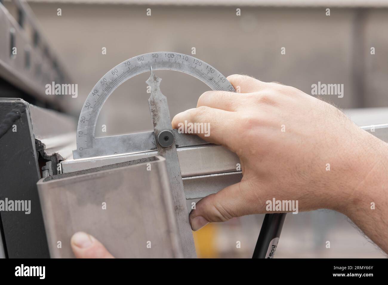 Angolo di misurazione su profili in alluminio con misuratore angolare. Mostra poco meno di 90 gradi. Foto Stock