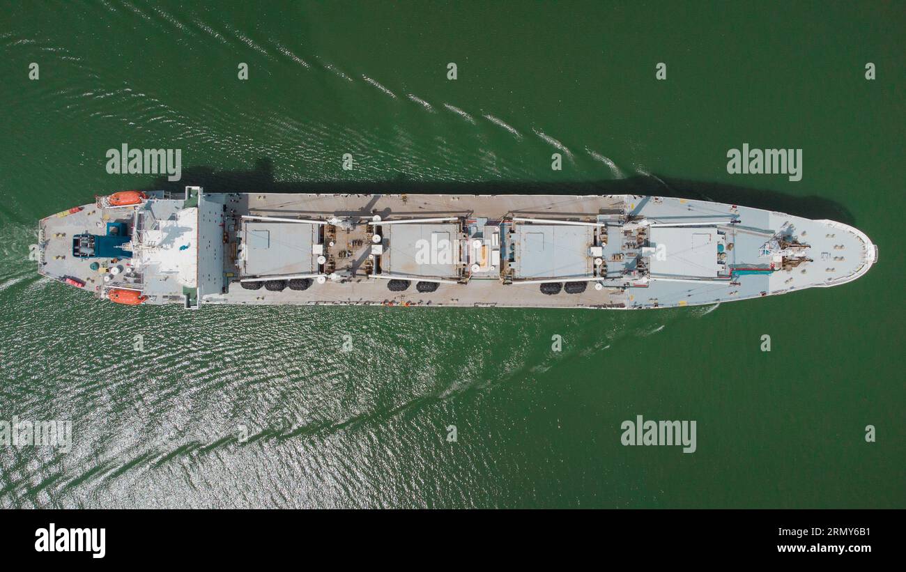 Nave da carico visibile dall'alto che naviga attraverso le acque dello stretto del canale di Panama. Nave grigia, vista aerea droni direttamente dall'alto. Foto Stock