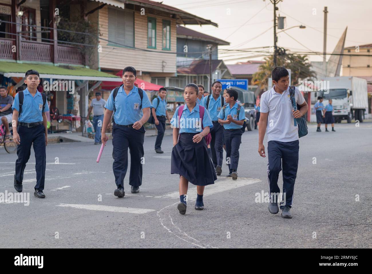 Bocas del Toro, Panama, 4,5.2023: I ragazzi delle scuole tornano a casa dalla scuola sulla strada principale, indossando le uniformi scolastiche. Scuola finita per il panamense Foto Stock