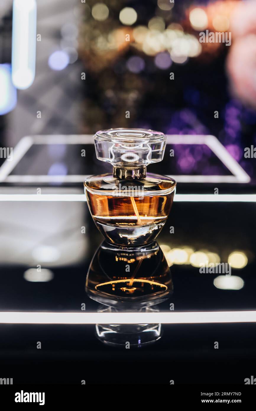 Bottiglia di profumo in vetro su un supporto a specchio. Boutique di profumeria di lusso. Copia spazio Foto Stock