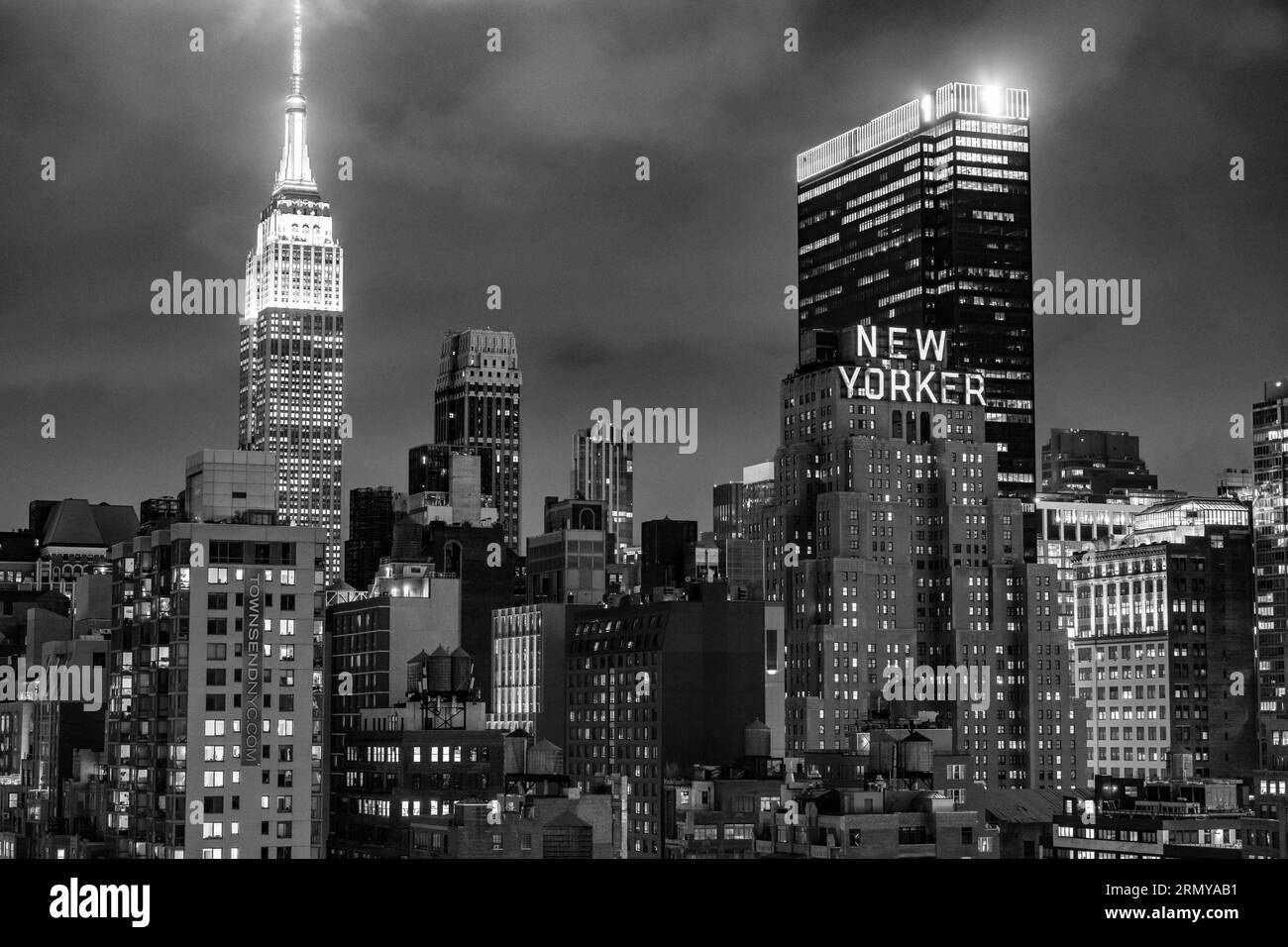 New York, New York, USA. 29 agosto 2023. L'Empire State Building (a sinistra) e il New Yorker Hotel (a destra) visti dall'Hell's Kitchen con lo skyline di Midtown New York City a night.Commercial immobili, economia di New York, grattacieli della finanza globale, affari internazionali, monumenti, attrazioni turistiche, osservatorio dell'Empire State Building. (Immagine di credito: © Taidgh Barron/ZUMA Press Wire) SOLO USO EDITORIALE! Non per USO commerciale! Foto Stock