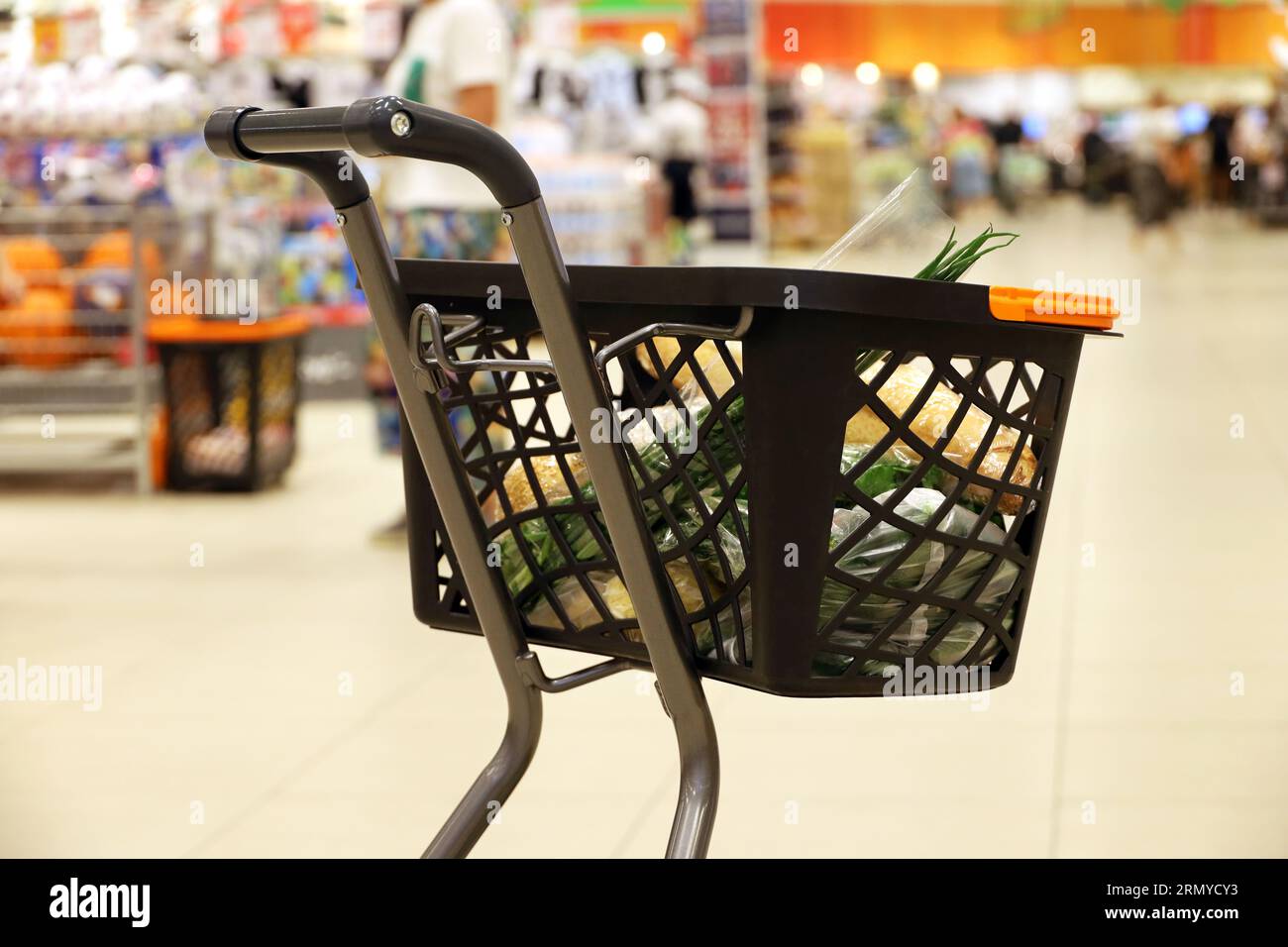 Carrello con cibo in un supermercato. Clienti durante la vendita Foto Stock