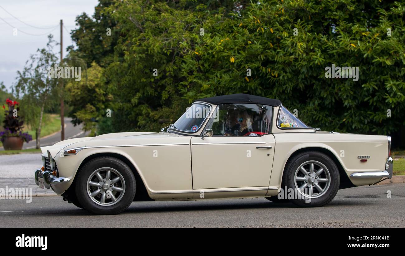 Whittlebury, Northants, Regno Unito - 27 agosto 2023: 1968 auto bianca Triumph TR5 che viaggia su una strada di campagna inglese Foto Stock