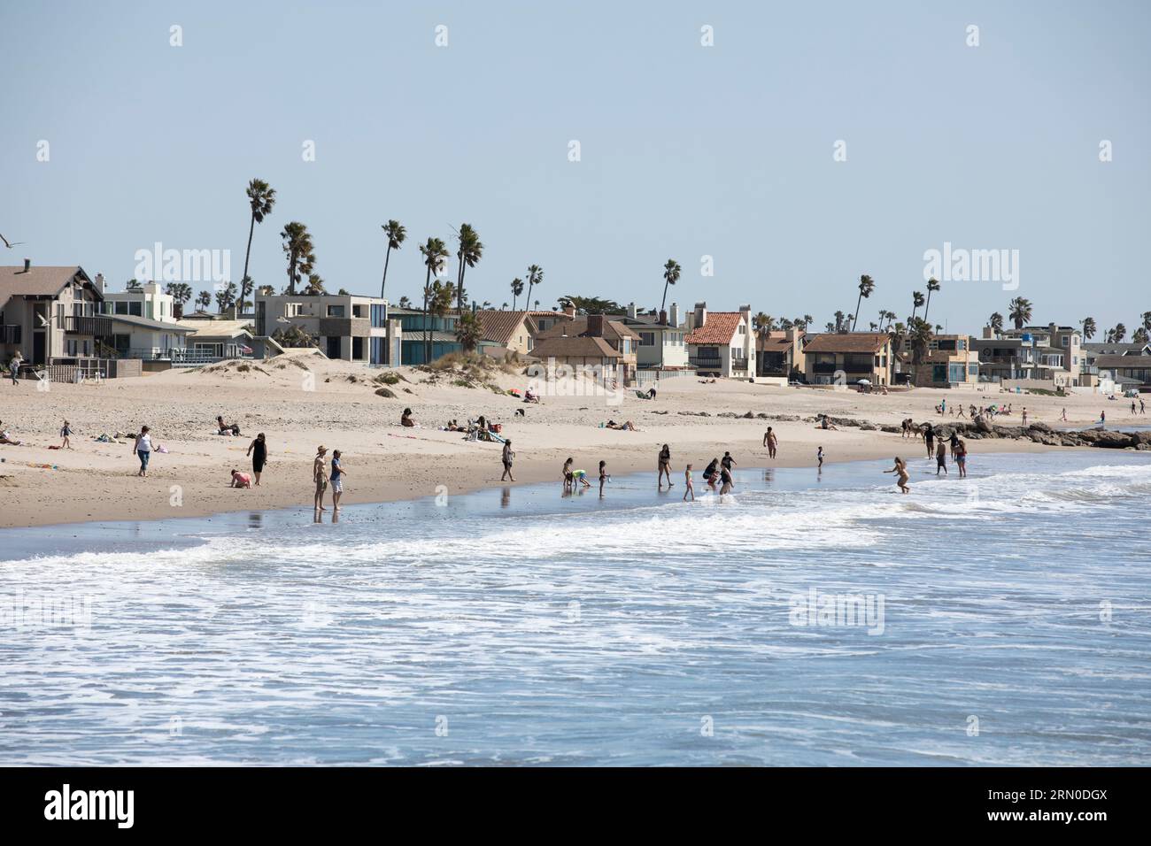 Ventura, California, USA - 31 marzo 2021: Il sole del pomeriggio splende mentre le onde si infrangono sulla spiaggia di Ventura, mentre le persone vanno a nuotare. Foto Stock