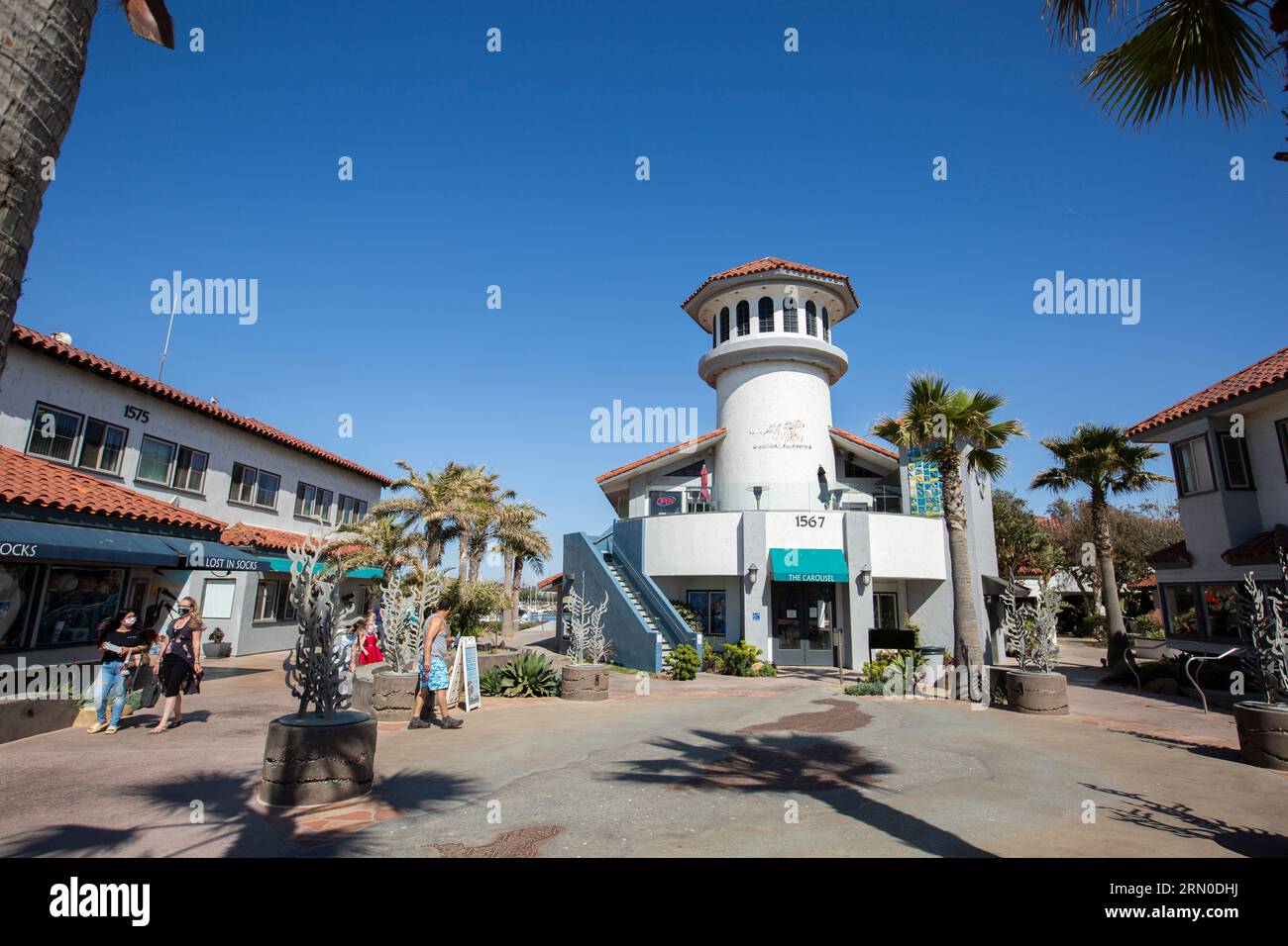 Ventura, California, USA - 31 marzo 2021: Il sole del pomeriggio splende sui negozi del Ventura Harbor Village vicino al porticciolo. Foto Stock