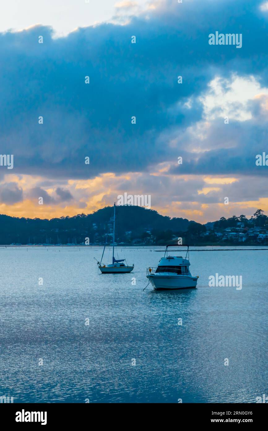 Alba, nuvole, barche e riflessi sul Brisbane Water a Koolewong e Tascott sulla Central Coast, NSW, Australia. Foto Stock