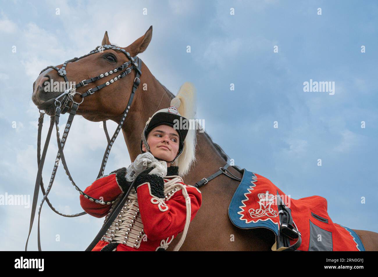 30 agosto 2023, Fredericia, Danimarca, ussaro rosso che fissa l'elmetto davanti al suo cavallo Foto Stock