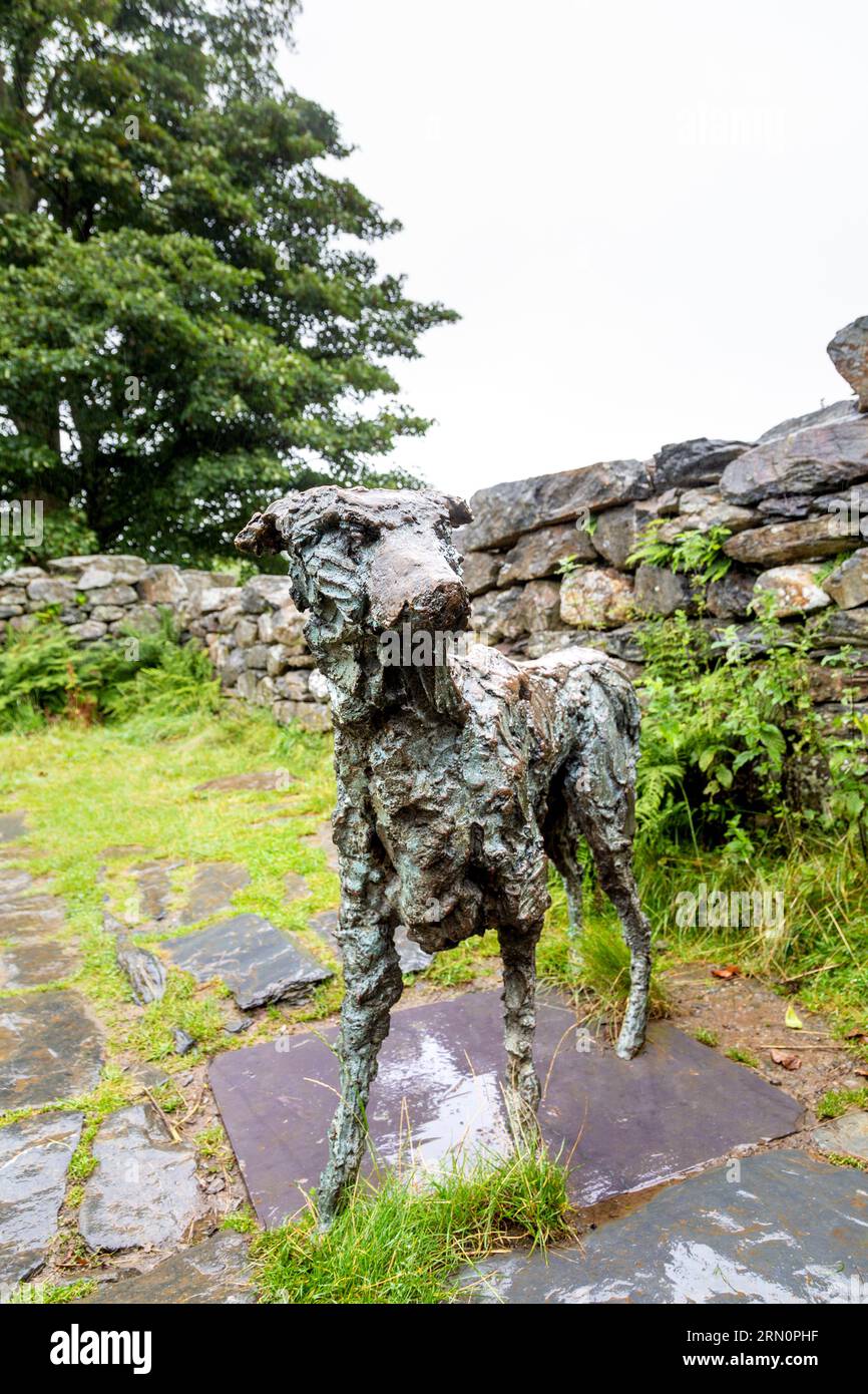 Scultura in bronzo del cane Gelert, posta in un cottage in rovina vicino alla tomba di Gelert, Beddgelert, Snowdonia National Park, Gwynedd, Galles, REGNO UNITO Foto Stock