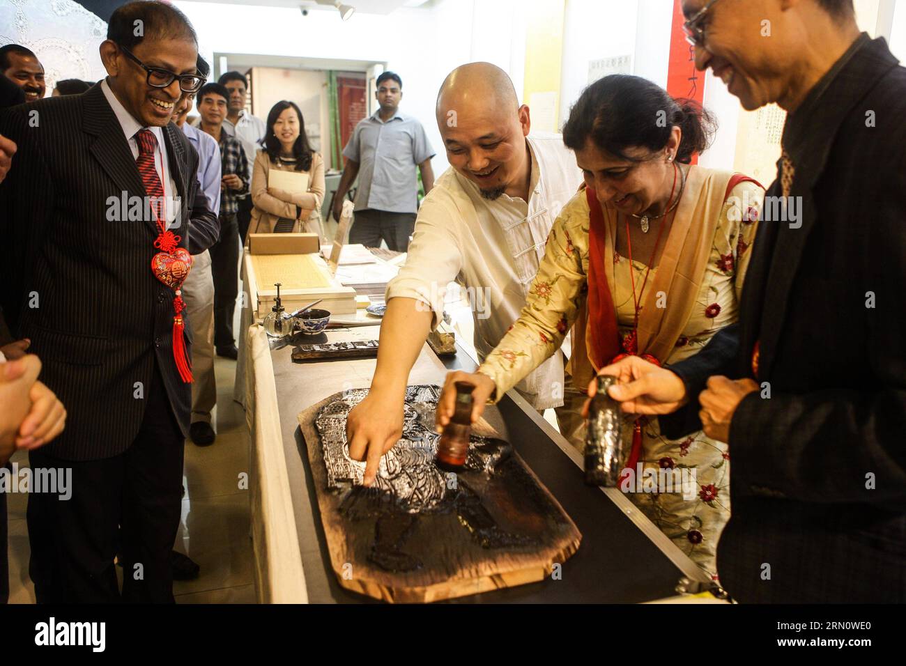 (141121) -- NEW DELHI, 21 novembre 2014 -- Wei Lizhong (3rd R), un rappresentante erede del patrimonio culturale immateriale dello Zhejiang e direttore della Hangzhou Shi Zhu Zhai Gallery, mostra la stampa di blocchi di legno alla sig.ra Jasminder Kasturia (2nd R) at the Heavenly Creations - Exhibition on Intangible Culture Heritage of China S Zhejiang Province, in the All India fine Arts and Crafts Society a New Delhi, capitale dell'India, 21 novembre 2014. La mostra di cinque giorni, che ha avuto inizio qui il venerdì con una selezione di tipici patrimoni della cultura immateriale di Zhejiang, mostrerà un'integrazione dell'arte statica Foto Stock