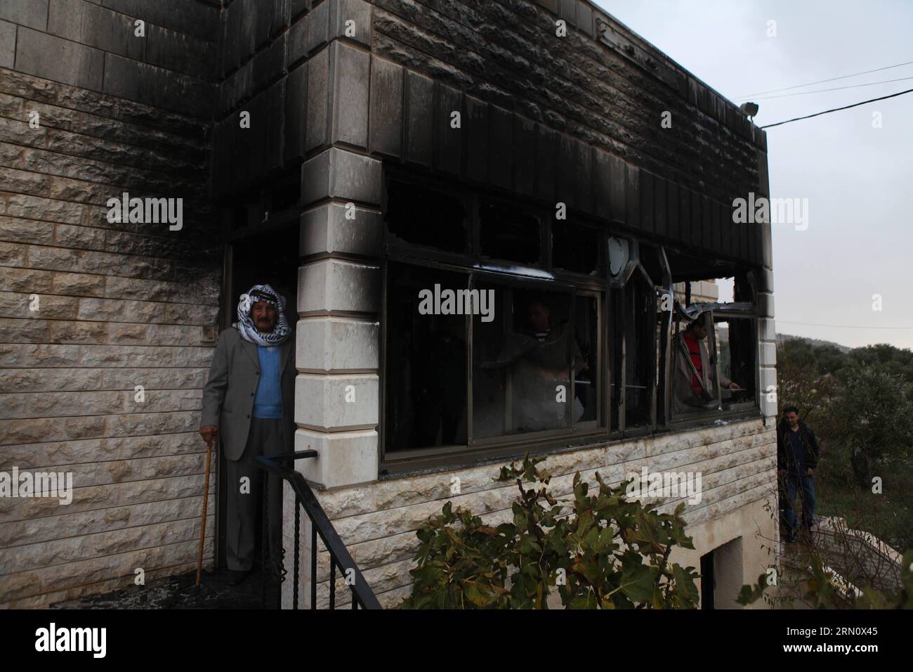 I palestinesi sono visti di fronte alla casa che è stata attaccata da bombe a benzina nel villaggio di Khirbat Abu Falah, a nord-est di Ramallah, il 23 novembre 2014. I coloni ebrei presumibilmente incendiano una casa di famiglia palestinese nella Cisgiordania occupata durante la notte, in un sospetto crimine d'odio in mezzo alla tensione crescente tra israeliani e palestinesi. Fadi Arouri) MIDEAST-RAMALLAH-INCENDIATO CASA EmadxDrimly PUBLICATIONxNOTxINxCHN PALESTINA sono laghi di fronte alla casa che ciò che ha attaccato dalle bombe a benzina nel villaggio di Abu Falah a nord-est di Ramallah IL 23 novembre 2014 i coloni ebrei presumibilmente hanno incastrato Abla Foto Stock