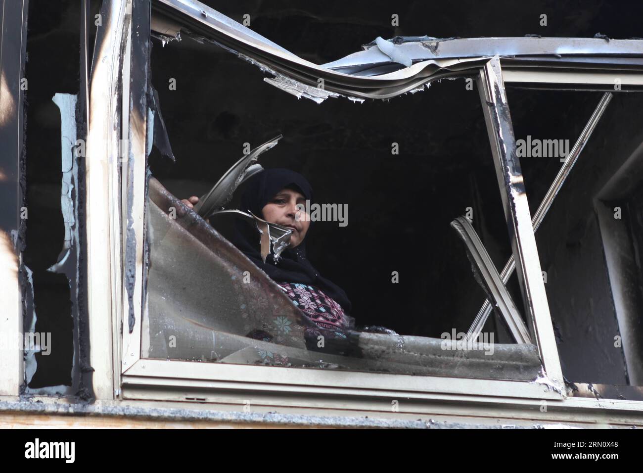 Una donna palestinese guarda da una finestra della casa del suo parente che è stata attaccata da bombe a benzina nel villaggio di Khirbat Abu Falah, a nord-est di Ramallah, il 23 novembre 2014. I coloni ebrei presumibilmente incendiano una casa di famiglia palestinese nella Cisgiordania occupata durante la notte, in un sospetto crimine d'odio in mezzo alla tensione crescente tra israeliani e palestinesi. Fadi Arouri) MIDEAST-RAMALLAH-INCENDIATO CASA EmadxDrimly PUBLICATIONxNOTxINxCHN una donna PALESTINESE guarda da una finestra della casa del suo parente che cosa ha attaccato dalle bombe a benzina nel villaggio di Abu Falah a nord-est di Ramallah IL 2 novembre Foto Stock